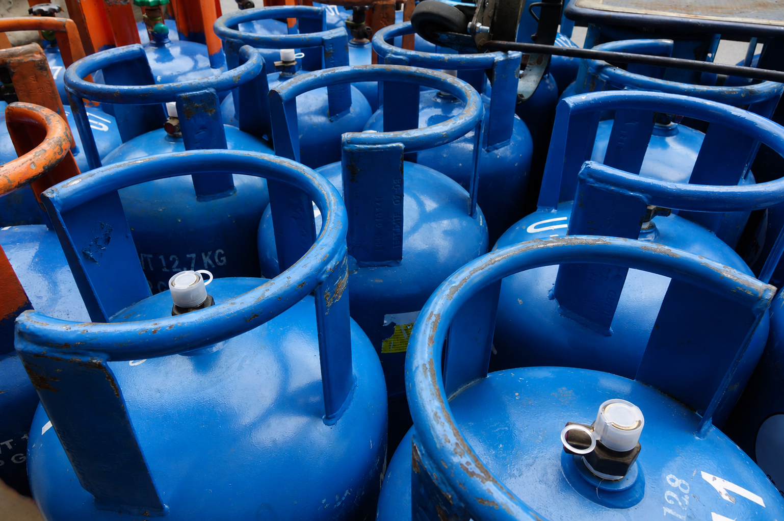 Bombole di gas blu impilate in deposito